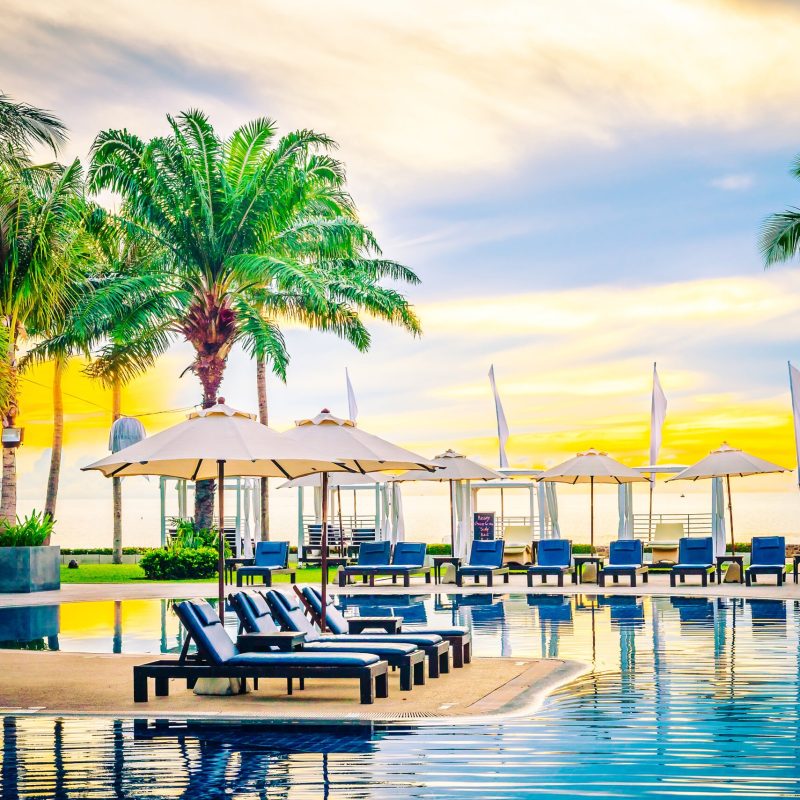 Umbrella in the luxury hotel pool resort at sunrise times - Vintage filter processing style pictures