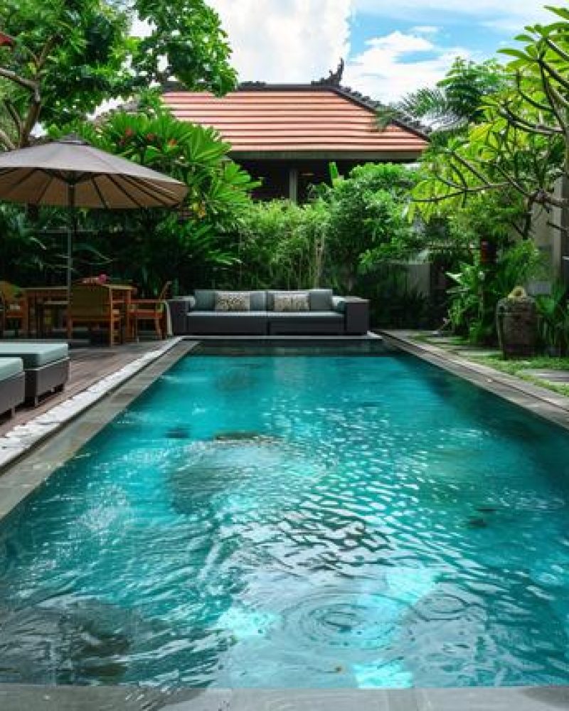 A swimming pool equipped with a comfortable sofa for lounging.