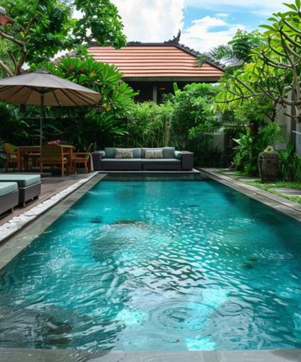 A swimming pool equipped with a comfortable sofa for lounging.